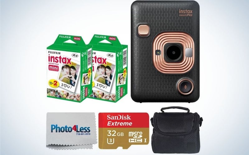 A black Fujifilm Instax Mini LiPlay Hybrid Instant Camera with two boxes in green Fujifilm Instax Instant Film, a grey Photo lens cleaner piece, a red and gold memory card and also a black compact camera case.