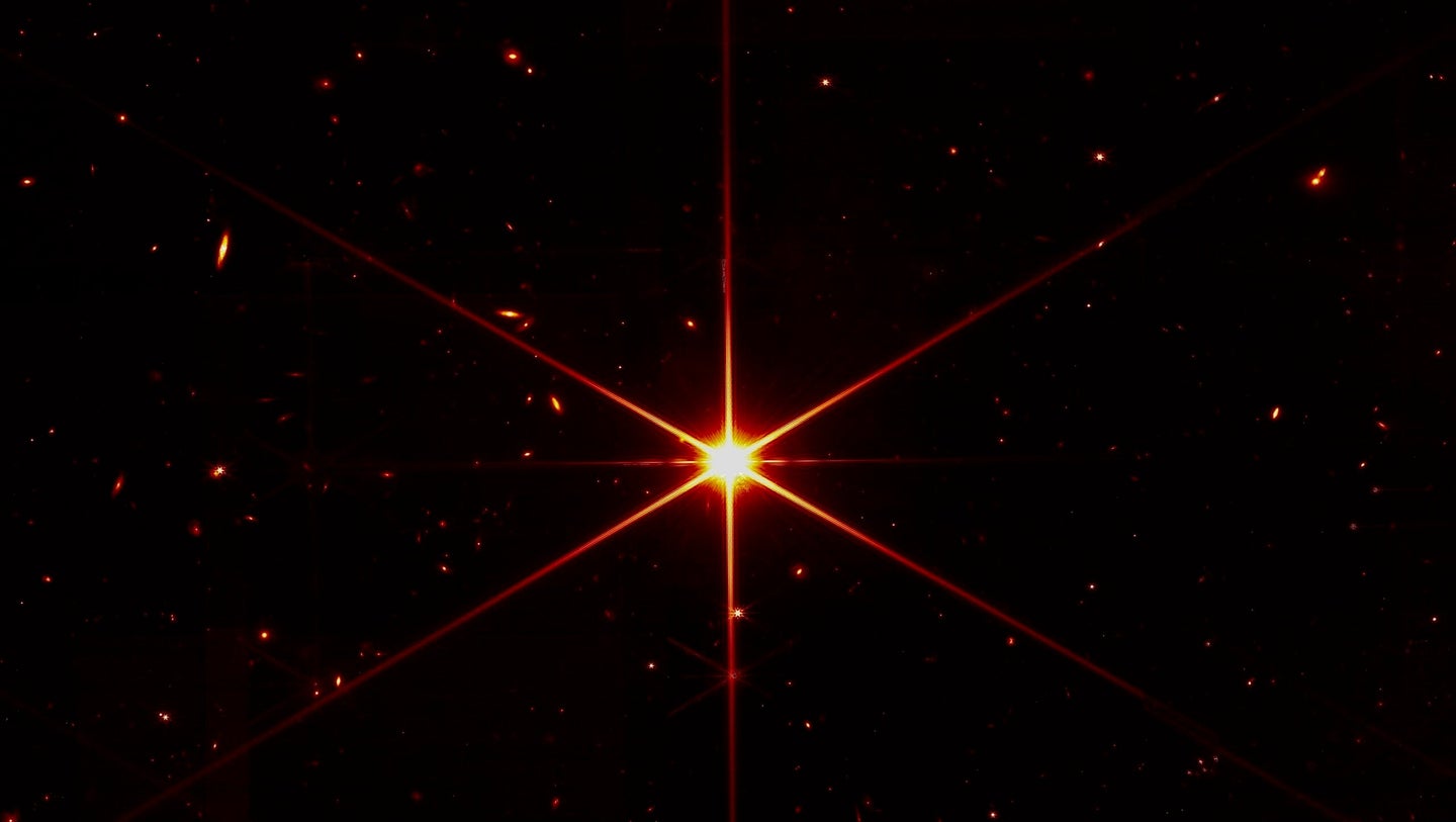 A bright star, with galaxies behind it, captured by the James Webb Space Telescope.