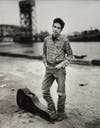 B&W portrait of Bob Dylan next to a guitar case by Richard Avedon.