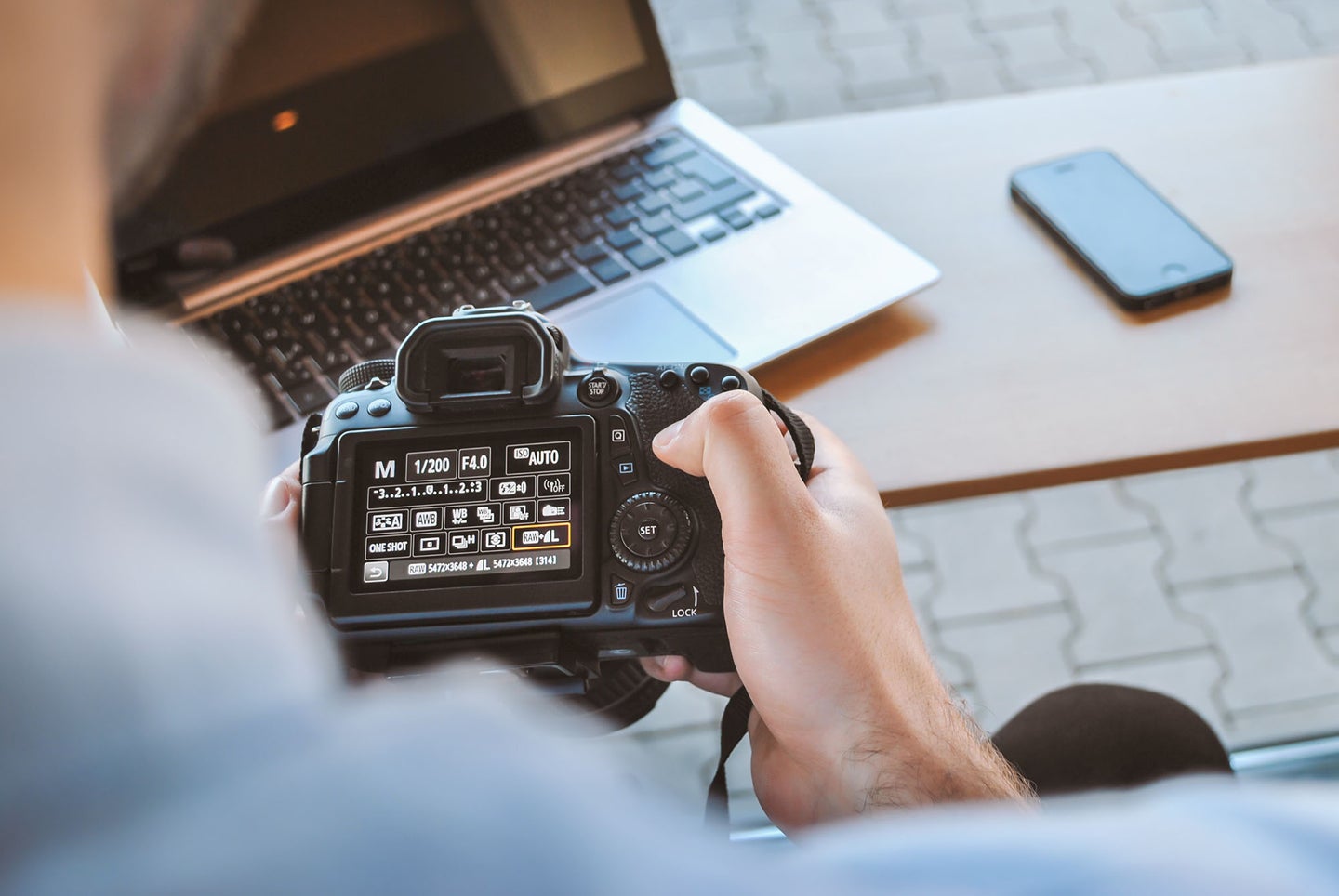 person with a camera and the best laptop for photo editing on a desk